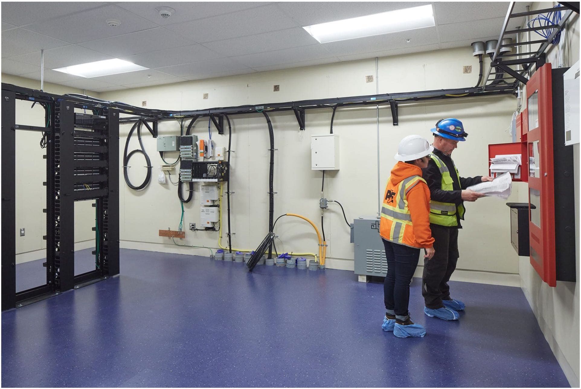 Two workers at a panels in a commercial setting to illustrate Commercial Maintenance and Troubleshooting