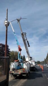 Electricians tearing down an old traffic signal at Lake Slough.