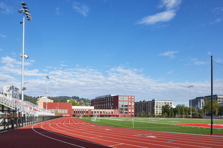 Lincoln High School features a running track with stadium lights and a green soccer field, ideal for sports events. For all your electrician needs related to stadium lighting and electrical maintenance at school facilities, certified professionals are available to ensure safe and efficient services.