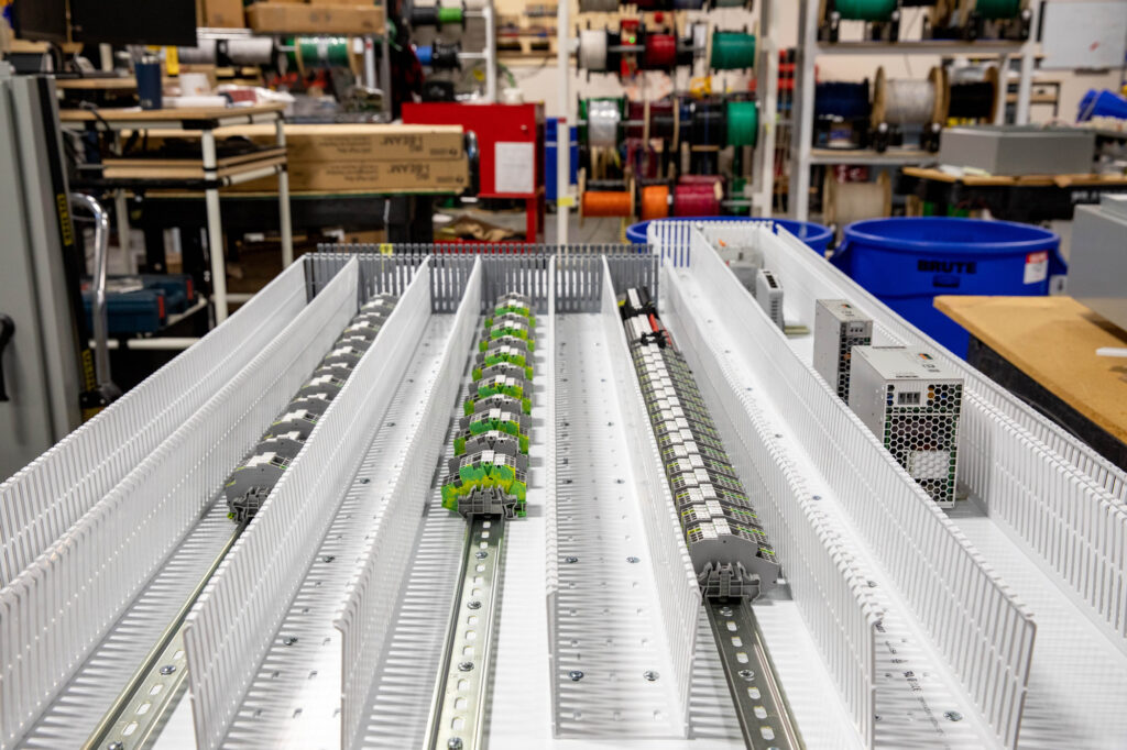 Close-up of an industrial electrical panel being assembled, featuring terminal blocks, wiring channels, and key components. Image taken at an electrician's workshop in Vancouver, WA.