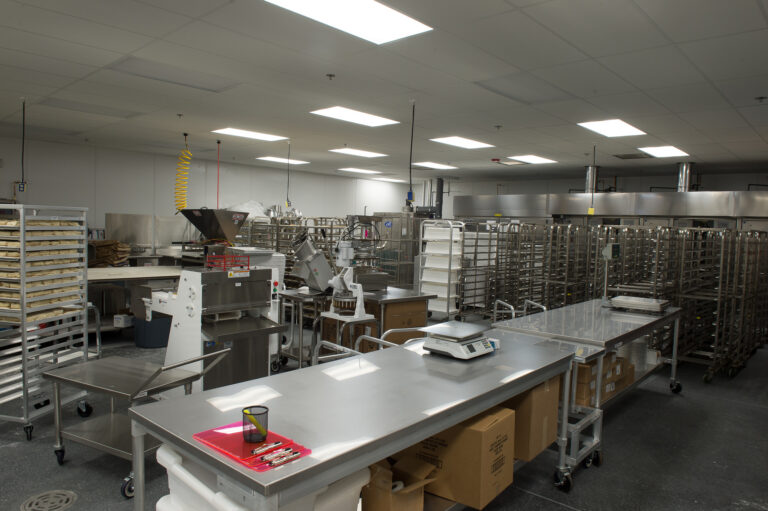 An industrial kitchen in Bellingham requires expert electrician services to maintain its bright fluorescent lighting and ensure optimal performance of equipment like scales and metal tables. If you're in Vancouver, WA, our electricians are ready to assist with similar needs to ensure efficiency and functionality in your space.