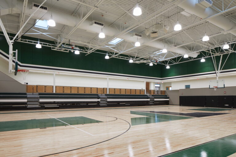 Tigard High School boasts a state-of-the-art indoor basketball court. Key features include polished wood floors, energy-efficient overhead lighting installed by professional electricians, and retractable bleachers for versatile seating. The space is ideal for athletic events and educational activities.