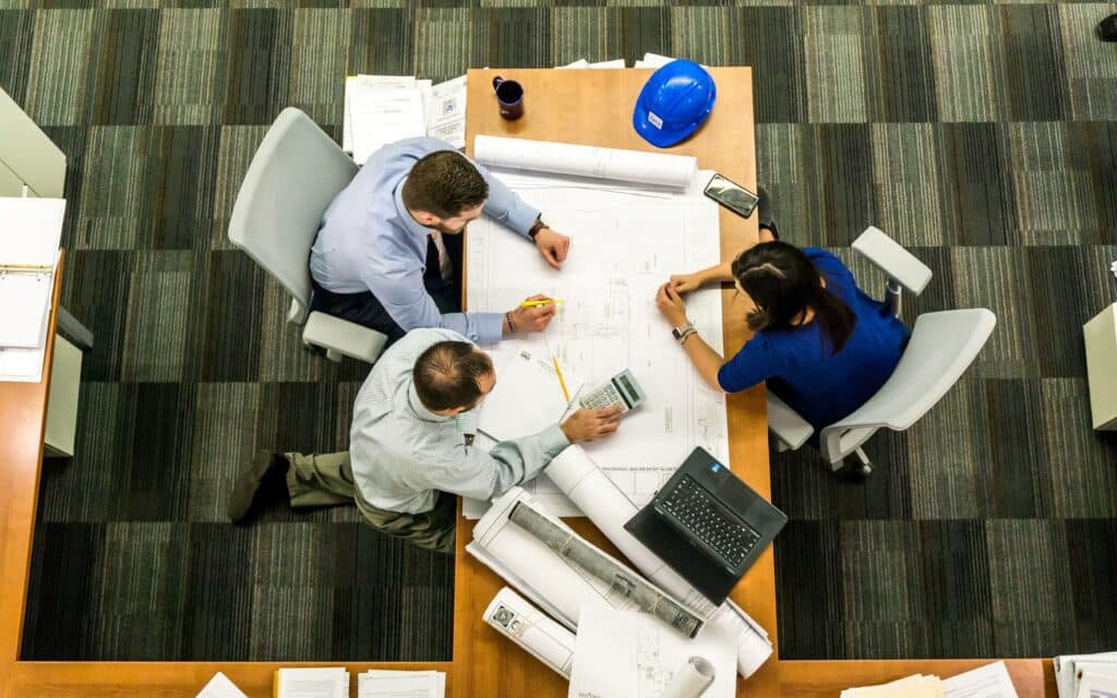 A team of electricians working at a table in an office located in Vancouver, WA.