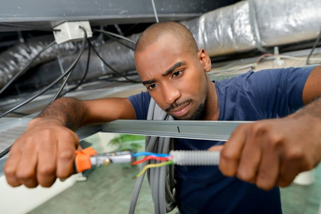 An electrician, possibly a residential electrical worker, is holding a wire in his hands in Vancouver, WA.