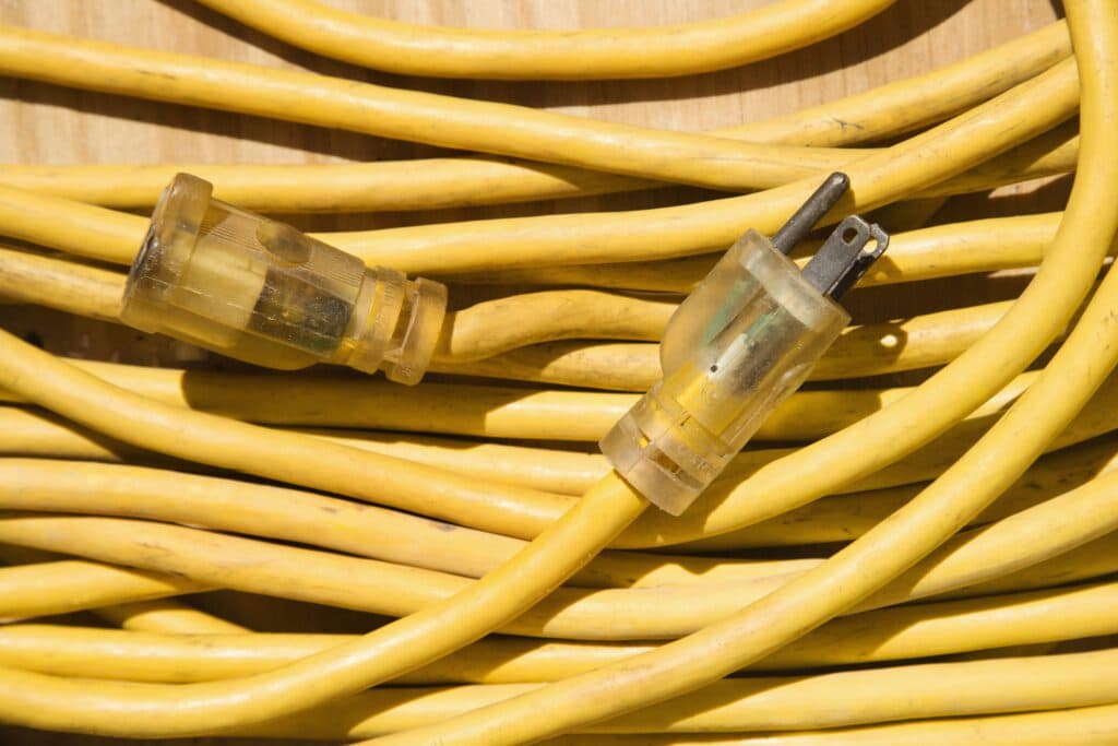 In Vancouver, WA, multiple electricians have scattered a number of yellow electrical cords across a wooden surface.