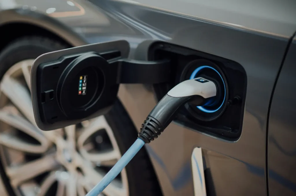 Close-up of an electric car being charged, with the charging plug connected to the vehicle's charging port