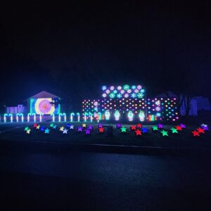 Professionally installed Christmas lights in Vancouver, WA: vibrant house and lawn displays, stars, and garage projection.