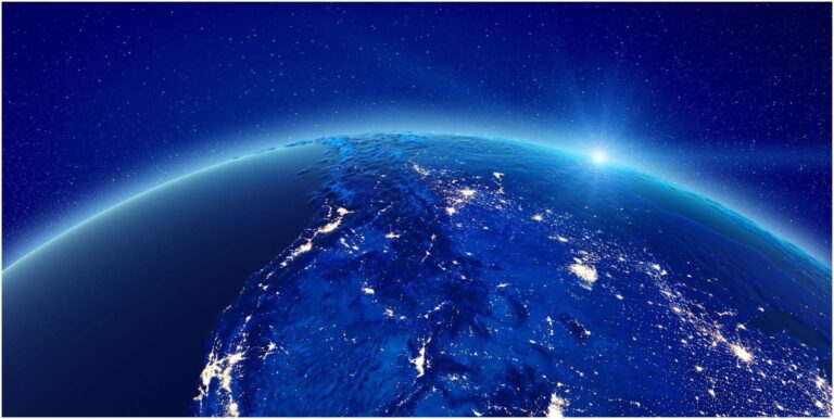 View of Earth from space with the sun rising over the horizon, illuminating the planet with a glowing blue hue and visible city lights, reminiscent of an electrician's handiwork. The image captures the curvature of the Earth and a star-filled sky.