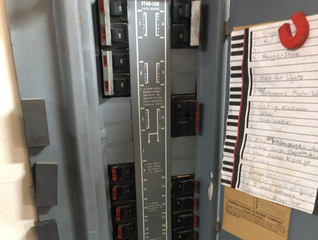 A circuit breaker panel, often accompanied by a note, is a common sight in the residential electrical work performed by electricians in Vancouver, WA.