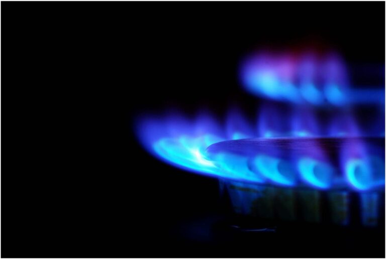 Close-up of a gas stove burner with blue flames against a dark background, reminiscent of the precision and expertise you'd expect from an electrician in Vancouver, WA.