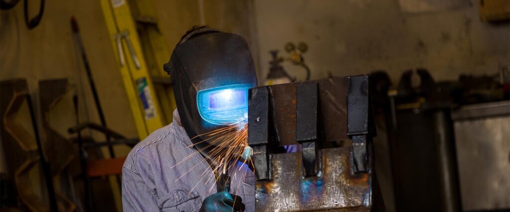 An electrician working on a piece of electrical equipment in a commercial setting in Vancouver, WA.