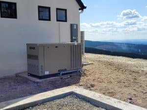 a larger home generator next to a structure to illustrate How Much Do Home Generators Cost What Factors Affect Price