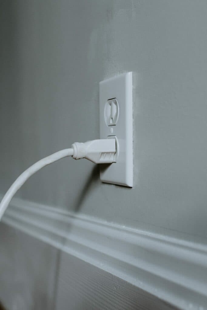 A white outlet with a cord plugged into it is a crucial element in residential electrical systems. This is a piece of everyday knowledge for local electricians in Vancouver, WA. They handle these systems regularly and have comprehensive understanding of how to manage them efficiently and safely.