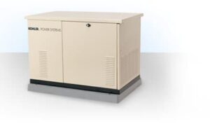 A beige Kohler power systems generator is shown, featuring a lockable front panel and ventilation slats. The generator, often recommended by an electrician in Vancouver WA, is placed on a grey base against a plain white background.