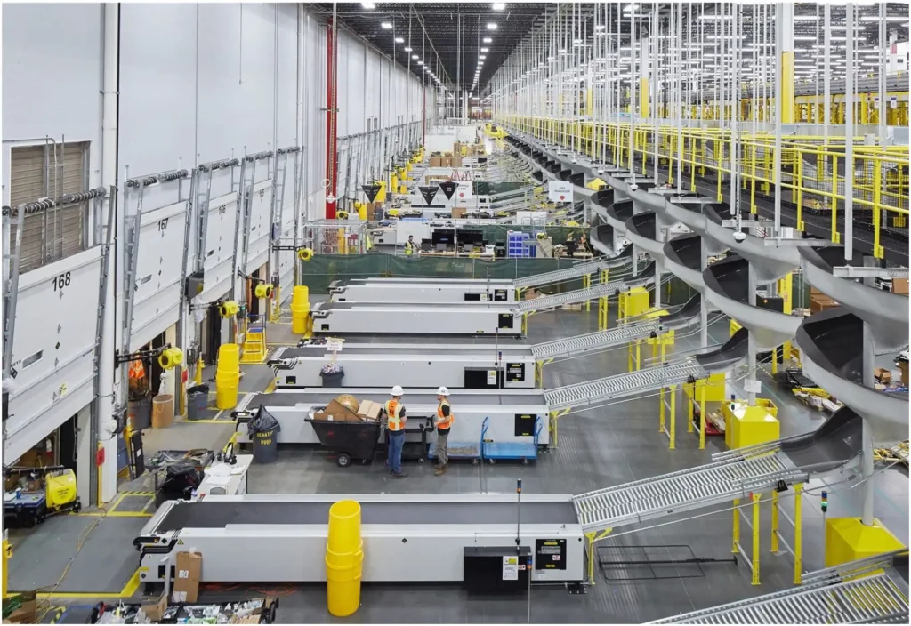 Brightly lit warehouse in Vancouver, WA featuring organized workstations and modern electrical systems powering conveyor belts, sorting equipment, and lighting. Skilled electricians ensure safe operation and maintenance of all electrical installations.
