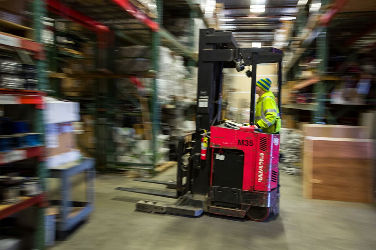 An industrial space with a technician riding a forklift.