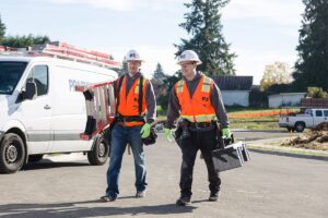 Residential electricians wearing orange vests from Prairie Electric in Vancouver, WA