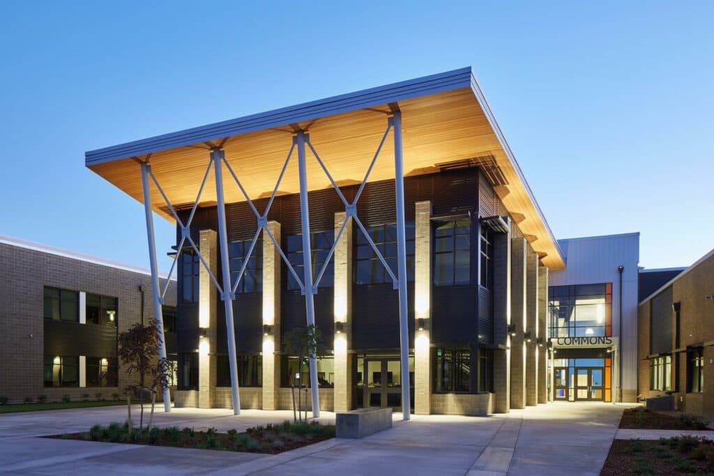 Vancouver, WA electricians illuminate the exterior of a modern building at dusk, showcasing its unique architectural features. These local electricians play around with creative lighting to highlight different aspects of the building's design.