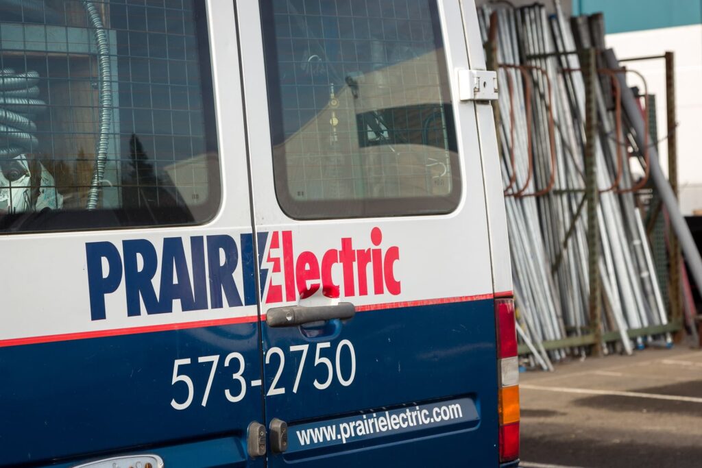 A blue and white van, owned by a local electrician, is parked in a parking lot in Vancouver, WA.