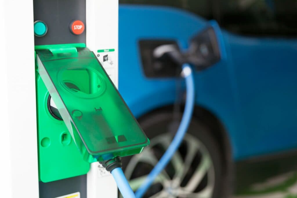 A commercial electrician is charging an electric vehicle at a charging station in Vancouver, WA.